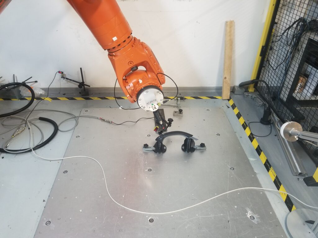 A six-axis robot arm tests the functionality of TG0's grab handle to determine if the response deteriorates over time