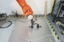 A six-axis robot arm tests the functionality of TG0's grab handle to determine if the response deteriorates over time