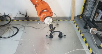 A six-axis robot arm tests the functionality of TG0's grab handle to determine if the response deteriorates over time