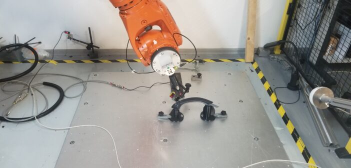 A six-axis robot arm tests the functionality of TG0's grab handle to determine if the response deteriorates over time