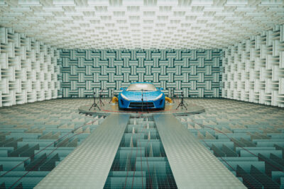 An advanced acoustic testing facility provides the backdrop for a sleek blue sports car being tested for sound dampening and performance optimization