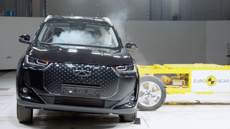 A vehicle undergoing a crash test in a controlled indoor testing environment.