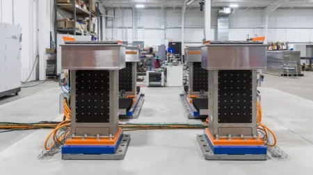 eMpulse servoelectric road simulators on a warehouse floor with a glass door and window behind.