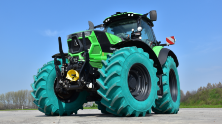 GRI Tires’ agriculture range delivers “superior performance” in Provana testing A tractor fitted with green GRI Tires exstands parked on a tarmac road with green bushes behind it and a blue sky above