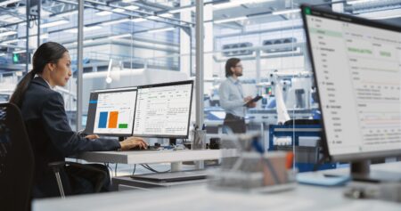 New NI SystemLink release tTwo members of staff talk in a bright office environment