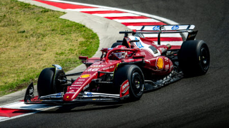 Pirelli tests 2026 F1 tires in Budapest A red Formula 1 car takes a turn on a motorsport racetrack at high speed
