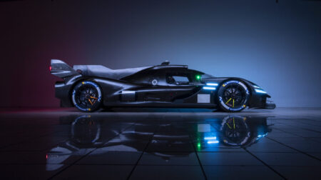 The Genesis Magma Racing GMR-001 Hypercar showin in profile, with black livery, against a black backdrop