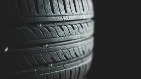Scientists call for deeper investigation and standardization for measuring and assessing tire wear emissions Stacked tires against a black background