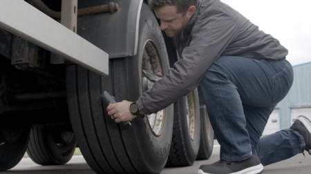 Transense Technologies managing director Ryan Maughan inspects a truck trailer tire with TLGX4
