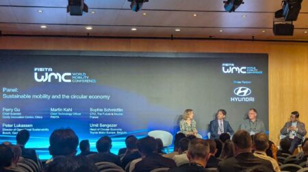 A panel discussion at FISITA's World mobility Conference 2025, with panel members sat on a stage in front of a presentation