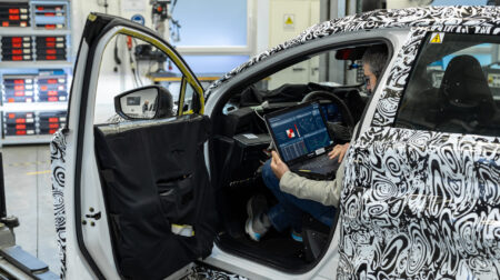 A test engineer sits in the driver seat of a Nissan test vehicle