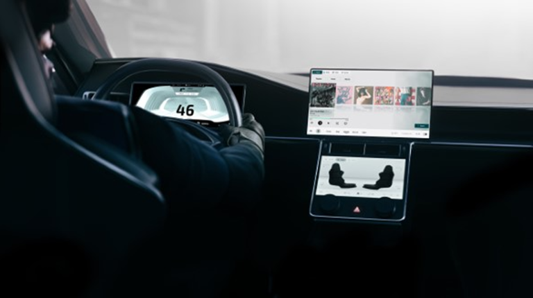 INTERVIEW: Inside Suzuki’s SDV cockpit powered by Qt The cockpit of a software-defined vehicle, with two large display screens and a smaller display behind the steering wheel. The driver has their hands on the wheel.