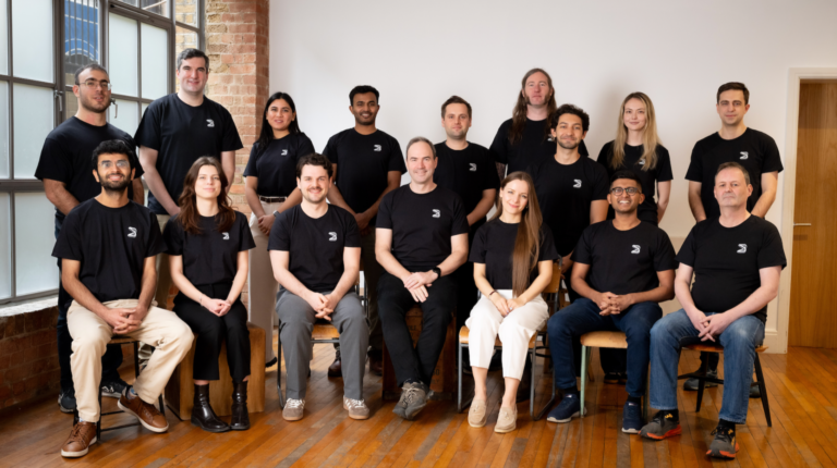 BeyondMath raises US$18.5m to scale foundational physics AI model BeyondMath team pose for a photograph. The front row are on seats, the back row standing. The floor is brown wood and the walls white.