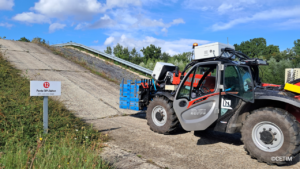An off-highway electric vehicle drives up a steep incline.