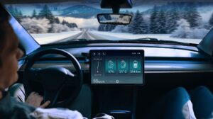 The TI battery monitor displaying information on a display screen on the dash of a vehicle driving through a cold, snowy environment.