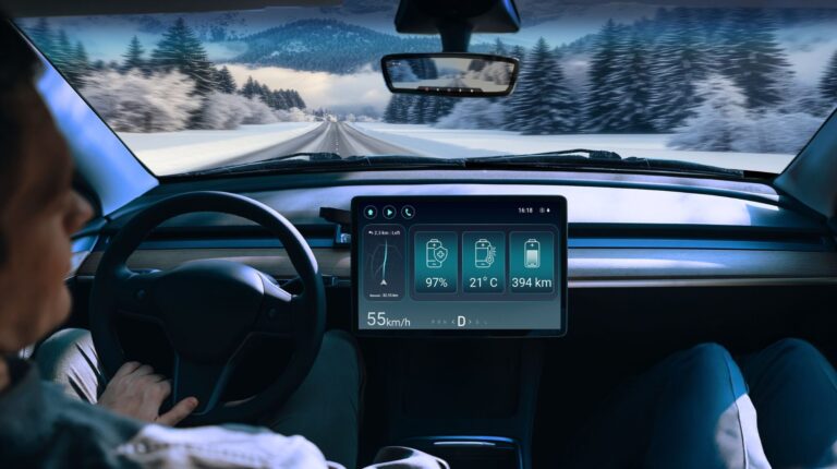 The TI battery monitor displaying information on a display screen on the dash of a vehicle driving through a cold, snowy environment.