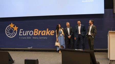 EuroBrake 2026 spotlights emissions, Euro 7 readiness, software-defined braking and integrated system design Representatives of FISITA and Vehicle Tech Week stand on a stage in front of a large screen displaying the EuroBrake 2026 logo.