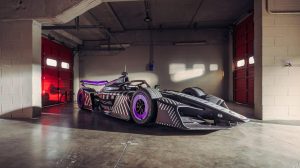Side-on view of the Porsche 975 RSE Gen4 Formula E race car in a showroom.