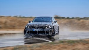 A camouflaged BMW 3 Series goes through testing in southern France, skidding through a high speed turn.