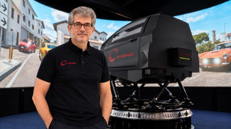 Dr Leonardo Pascali standing in front of a driver simulation machine.